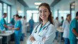 © abu - A confident young female doctor smiles with crossed arms in a busy hospital corridor, with healthcare professionals working around her.
