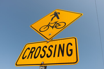 pedestrian and bike crossing sign on a summer blue sky