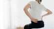 © Ton Photographer4289 - Woman holding her lower back while sitting in bed has chronic back pain. Health Care concept
