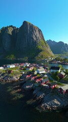 Wall Mural - experience an aerial view of reine, norway, highlighting its charming red houses set against dramati