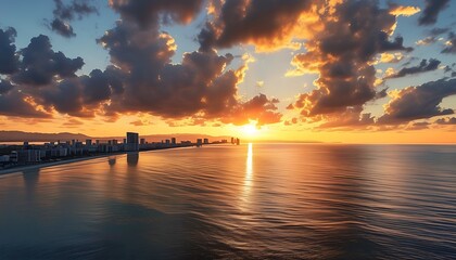 Wall Mural - At sunset, the harmonious scenery of the coastline and the city, with the warm golden brilliance of the clouds, makes people feel peaceful and beautiful.