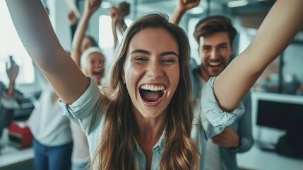 A joyful woman with arms raised, celebrating with friends in a modern office. The group shows enthusiasm and camaraderie, capturing the essence of teamwork and success in a professional environment.