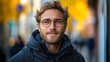 © Рудой Максим - Young man with glasses smiles outdoors amidst autumn foliage in a bustling city environment during a sunny day