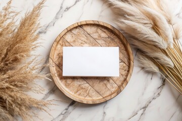 A blank card rests on a plate with pampas grass.