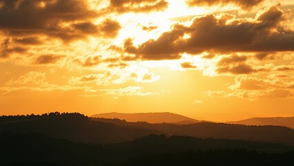 Poster - Golden sunset over a silhouette of mountains.