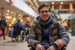 © ckybe - Photograph of a cheerful white college-aged man with a disability using a wheelchair.
