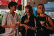 © qunica.com - A group of friends having a good time on a night out, enjoying cocktails and engaging in lively conversation in a sophisticated setting.