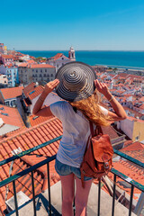 Wall Mural - back view of female tourist enjoying rooftop lisbon city landscape. travel in portugal
