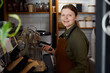 © Nomad_Soul - Portrait of smiling woman barista wearing apron standing in coffee shop
