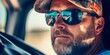 © Murda - Man in sunglasses and cap driving car.