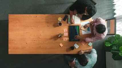 Wall Mural - Group of diverse people sharing idea while writing at colorful sticky notes. Top down view of smart business team brainstorming idea and planning strategy for startup project. Time lapse. Convocation.