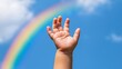 © Rungthiwa - Child's hand reaching towards a rainbow