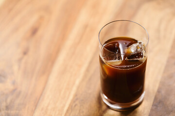 Glass of iced coffee on wooden table