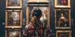 © Maftuh - woman looking at the paintings in an art gallery.