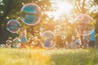 © Archibalttttt - Soap bubbles floating over green grass in summer park with children playing