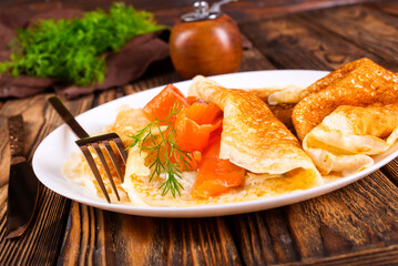 Wall Mural - Pancakes with salmon (trout). Thin, not sweet blinchiki stuffed with red fish.