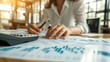 © AlfaSmart - Businesswoman Analyzing Financial Data with Calculator and Charts