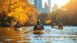 © rabbit75_fot - A person kayaking in still lake water with colorful Autumn foliage woods and city skyscrapers.