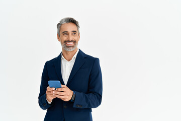 Smiling mature business man in suit using cellphone looking aside. Happy middle aged professional businessman holding mobile phone standing isolated on white. Bank finance app on smartphone ads.