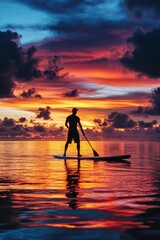 Wall Mural - A man doing paddleboarding in water at sunset with colorful dusk sky