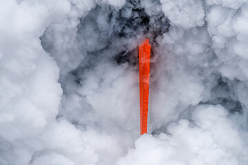 Wall Mural - Lava tube flowing into ocean in Hawaii at dawn shows the poisonous steam rising as the hot liquid hits the ocean.