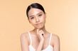 © 220 Selfmade studio - A thoughtful young woman pondering a question with a soft expression against a warm orange background.