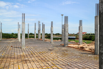 Wall Mural - A construction site with concrete columns and reinforcing steel bars, showing the framework for a new building project. Concrete pillars and a steel mesh floor await the next stage of construction.