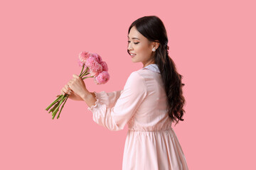 Sticker - Beautiful young Asian woman with bouquet of dahlias on pink background