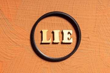 A wooden circle with the letters LIE written in it