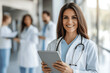 © RookStock - Confident female doctor holding a tablet in a hospital setting, smiling warmly, representing professionalism, healthcare, and patient care in a bright and modern medical environment