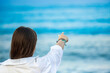 © BUCSA - beautiful young girl pointing to the sea on tropical island beach