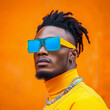 © ChaoticDesignStudio - Man in bold sunglasses poses against orange background