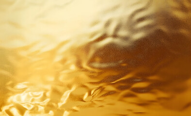 Shiny gold foil polished background with the reflection of golden light.