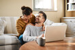 © Chanelle2000/peopleimages.com - Happy couple, laughing and laptop in house for choice, news and loan option online in living room. Relax, support or funny people in lounge on social network app on digital website and technology