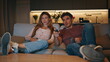 © stockbusters - Resting pair watching movie at cozy sofa together. Lovers discussing funny show