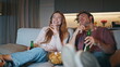 © stockbusters - Loving couple watching movie sitting night closeup. Happy family clinking beer