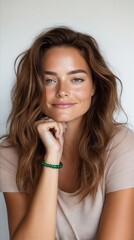 Wall Mural - A woman with long brown hair wearing a green bracelet