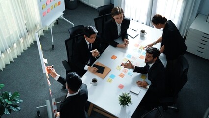 Top view of smart executive manager financial graph to diverse team while group of multicultural business people planning marketing strategy by using stock investment chart at meeting. Directorate.