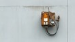 © Nima - A weathered and rusty industrial electrical box with wires and a gauge mounted on a white concrete wall. The box symbolizes industry, power, age, and the passage of time.
