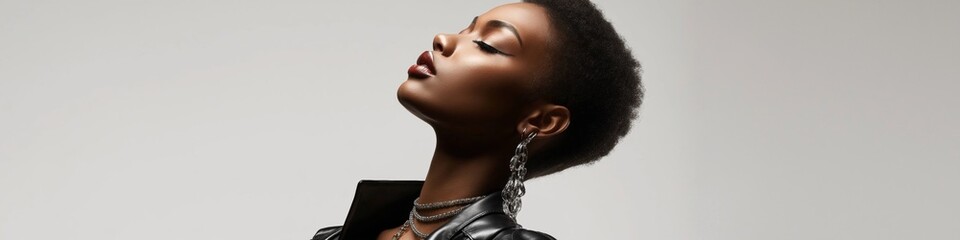 Wall Mural - A woman with short hair and a black jacket. She is wearing a necklace and earrings. The image has a mood of elegance and sophistication