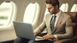 © rohappy - Confident businessman passenger, man working with laptop on an airplane sits in seat business class