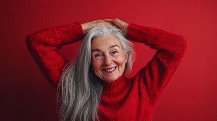 Poster - A joyful older woman smiles brightly against a bold red backdrop. She expresses confidence and warmth with her long gray hair. Ideal for portraits and lifestyle themes. AI