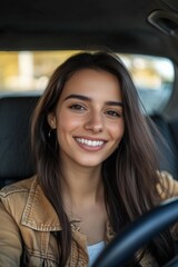 Wall Mural - Young woman smiling while sitting in the driver's seat of a car