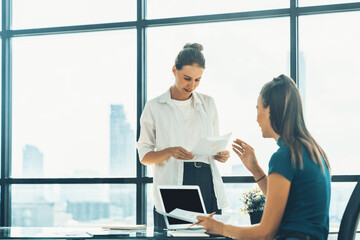 Professional businesswoman discuss about financial plan by using statistic document. Group of businesspeople brainstorming and sharing idea at modern office. Working together and business. Tracery.