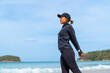 © CandyRetriever  - Asian woman in sportswear stretching body after jogging exercise at tropical island beach. Healthy girl enjoy outdoor active lifestyle sport training running fitness workout on summer holiday vacation