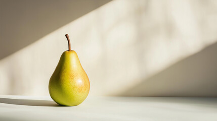 a single pear with a smooth, golden-green skin and stem against an isolated white background