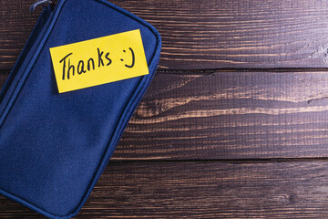 A note with the word thank you on a blue soft box on the table