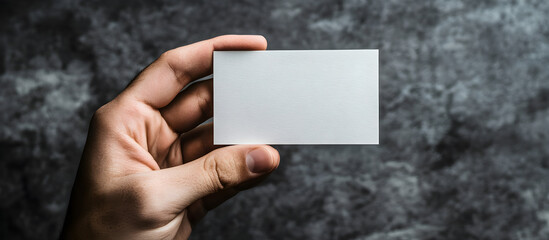 A hand holding a white business card