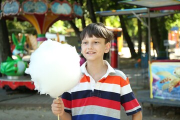 Wall Mural - Portrait of little boy with sweet cotton candy in park