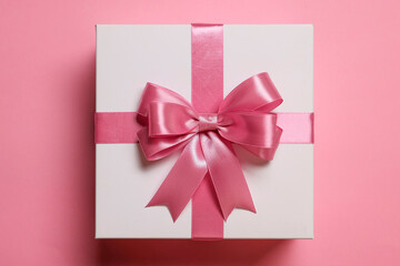 Poster - Gift box with bow on dusty pink background, top view